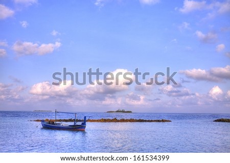 A small blue boat peacefully rests on smooth waters.