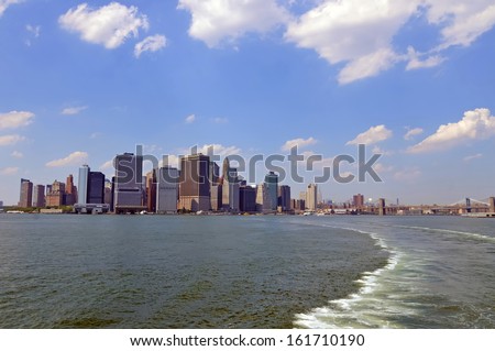 A city of tall buildings sitting on the edge of a body of water.