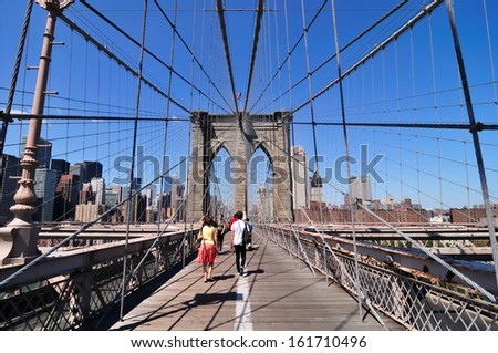 A man and a woman walking across a bridge.