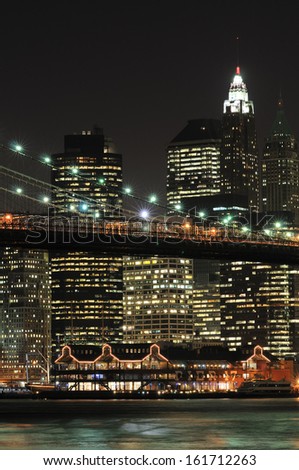A brightly lit city skyline at night from the water\'s edge.