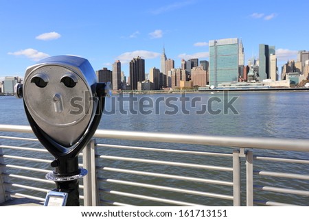 A tower viewer looking out over a body of water towards a city.