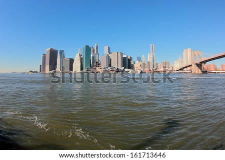 A city with multiple large buildings sitting on the edge of a body of water.