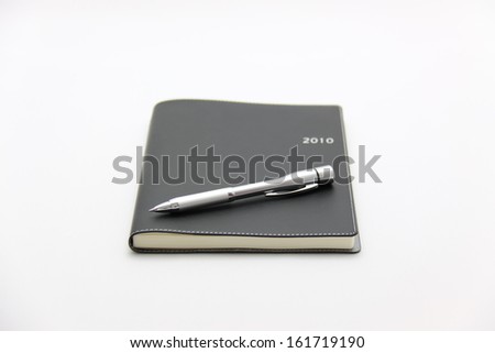 A pen resting on top of a daily planner.
