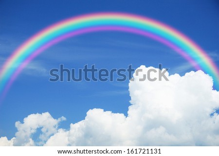 A Bright Rainbow Curves Over A Blue Sky And Fluffy Clouds.