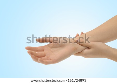 A left hand holding a right hand at the wrist.