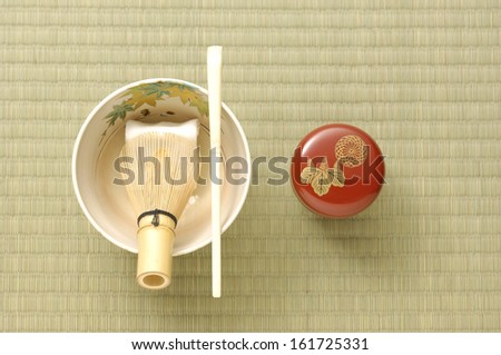A bowl and chop sticks on a wicker table.