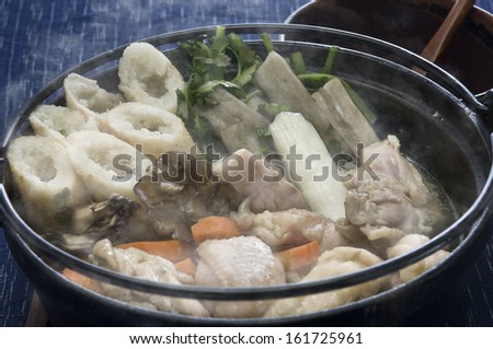 A steaming pot filled with vegetables and seafood.