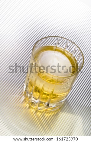 A glass filled with a yellow liquid.