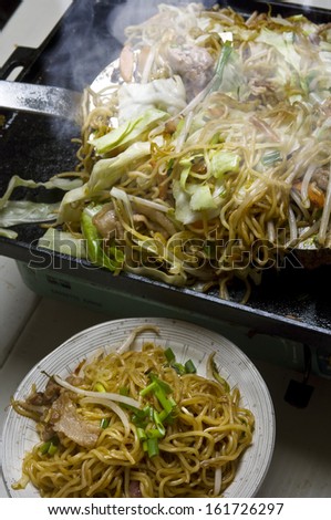 A plate of steaming noodles and stir fried vegetables.