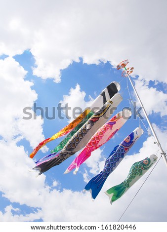 Five flags are blowing in the wind and hanging from a pole.