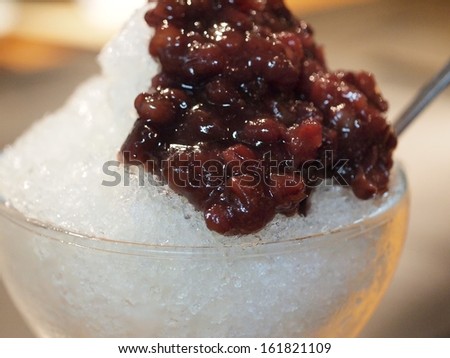 A clear glass filled with ice topped with cranberries.