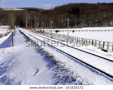 Snow covered railway track and landscape in winter