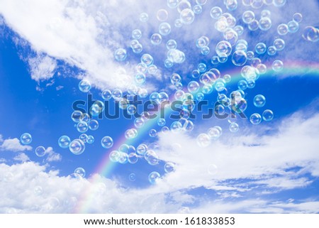 Soap bubbles in the cloudy sky with rainbow