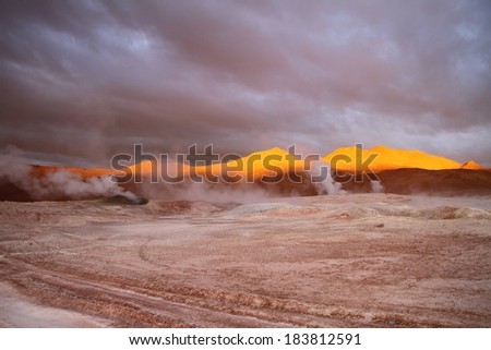 A vast, gloomy landscape with smoke coming out of the ground.