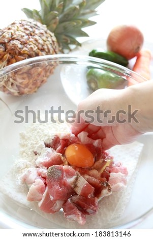 Somebody is stirring together an egg, meat and flour for a dish.