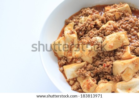 On the right, a white bowl with tofu cubes, ground meat, and sauce.