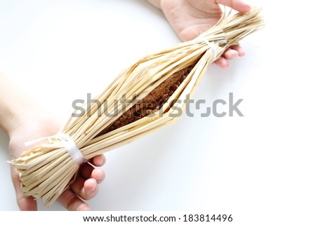 Food wrapped in straw and tied at each end.