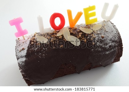 A small chocolate dessert with colorful letters on top spelling \