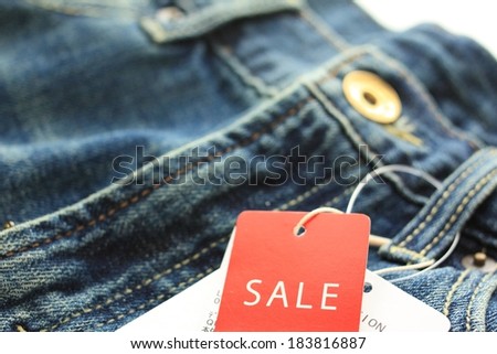A pair of blue jeans with the sale tag on it.
