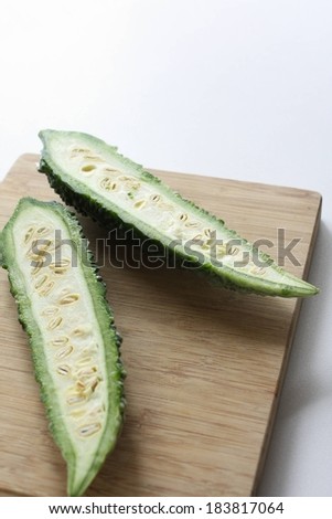 A bitter melon cut in half showing the seeds.