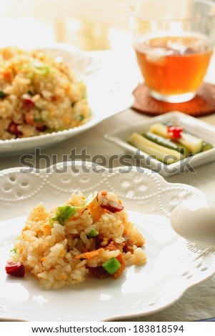 Rice and vegetables on a plate with a drink next to it