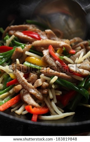 A colorful stir fry with lots of vegetables and meat strips.