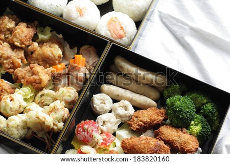 Three boxes containing broccoli, meat and rice balls.