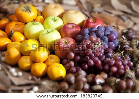 Selective focus image of a variety of foods including grapes and apples lumped together.