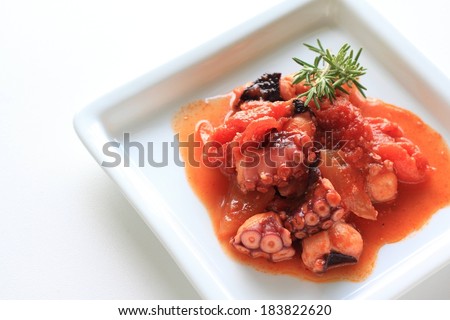 A dish of octopus with a red sauce.