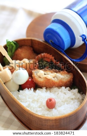 A bowl with a variety of food and a blue canteen.
