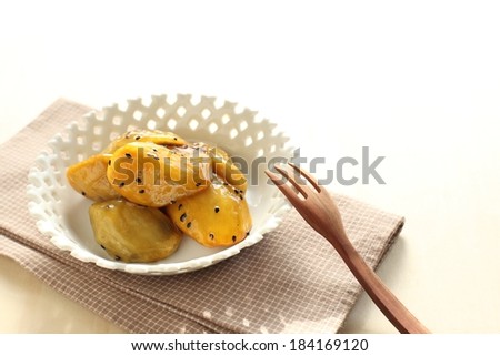A bowl of glazed food with a wooden fork leaning against it.
