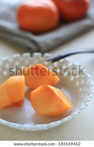 Three pieces of orange food placed in a white bowl.