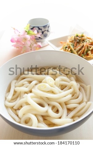 A round white bowl containing several noodles and liquid.
