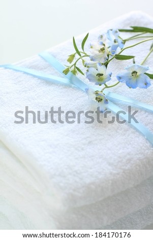 A sprig of flowers is on a folded cloth with a ribbon.