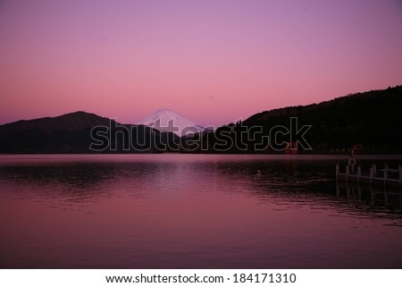 A snow-covered mountain behind a body of water.