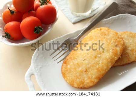 Two potato patties on a white tray with a fork.