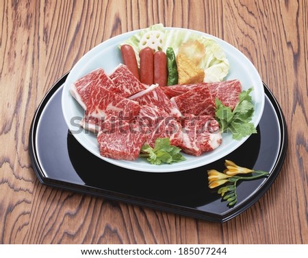 A plate containing cut meat and other finger foods