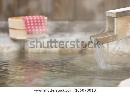 Water flowing from a wooden trough to a pond.