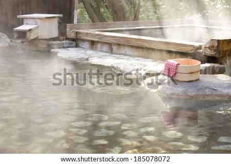 A steaming hot spring with a bucket and towel.