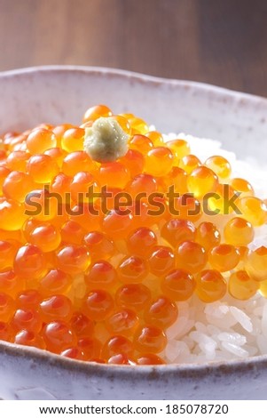 A dish of white rice, and orange fish eggs.