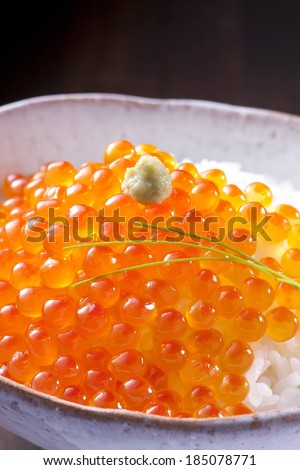 Fish eggs, rice and dressing in a small bowl.
