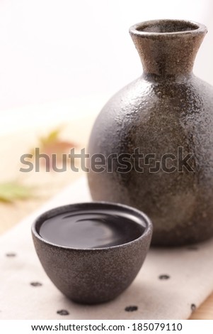 A brown jug, and cup filled with a brown liquid.