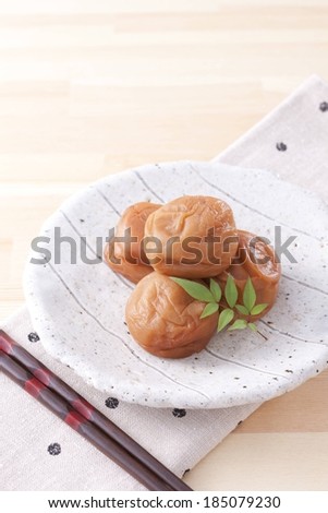A stack of food sitting on a plate with chopsticks beside it.