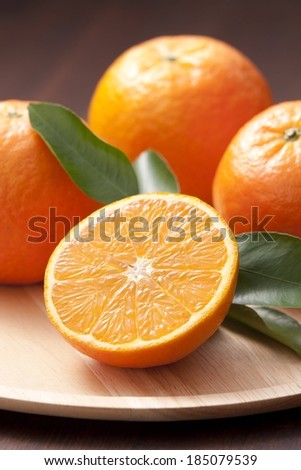 A number of oranges sitting on a cutting board.