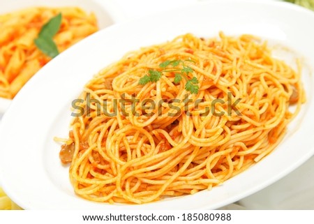 Two white bowls full of two kinds of pasta.