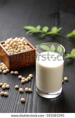 A glass of milk sitting beside a box of seeds.