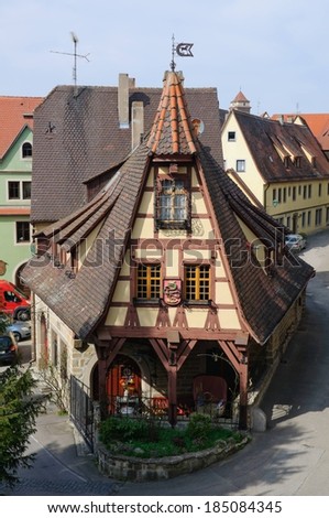 A steep-roofed medieval-style house on a small corner, Germany.