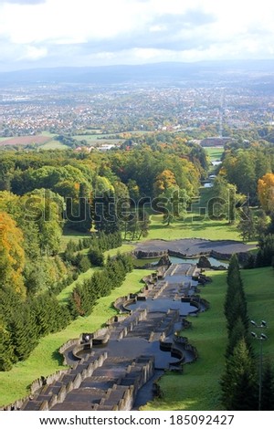 View from the top of an ornamental cascade or water steps in the landscape garden of a large country house near a town.