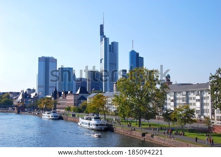 Boats moored on the riverside under the skyscrapers of downtown, Frankfurt-am-Main, Germany.