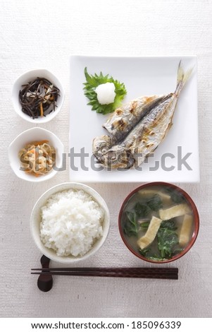 A cooked fish with a collection of other foods.